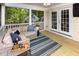 Inviting screened-in porch features a comfortable seating area and a view of the lush surroundings at 9417 Greenfield Dr, Raleigh, NC 27615
