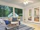 Cozy screened-in porch with white railings, comfy seating, and double doors at 9417 Greenfield Dr, Raleigh, NC 27615