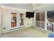 Covered porch with a ceiling fan, outdoor tv, and double doors opening to the interior at 9417 Greenfield Dr, Raleigh, NC 27615