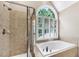 Bathroom with a stand-up shower, and jacuzzi bathtub with large window at 1001 Dairy House Ct, Wake Forest, NC 27587