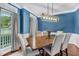 Elegant dining room with wainscoting, wood floors, a modern chandelier, and natural light at 1001 Dairy House Ct, Wake Forest, NC 27587