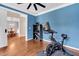 Bright exercise room with hardwood floors, blue walls, and modern exercise equipment at 1001 Dairy House Ct, Wake Forest, NC 27587