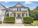 Stunning home featuring a welcoming front porch with white columns and manicured hedges, inviting guests at 1001 Dairy House Ct, Wake Forest, NC 27587