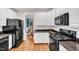 Modern kitchen with white cabinets, black appliances, subway tile backsplash, and wood floors at 1001 Dairy House Ct, Wake Forest, NC 27587