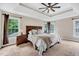 Main bedroom features a large bed, tray ceiling and multiple windows at 1001 Dairy House Ct, Wake Forest, NC 27587