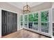 Bright sunroom with hardwood floors, large windows overlooking the deck, and black closet doors at 1001 Dairy House Ct, Wake Forest, NC 27587