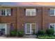 Charming brick townhouse with purple shutters and well-maintained landscaping at sunset at 103 Coleridge Ct, Carrboro, NC 27510
