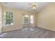 Spacious bedroom with large windows, a ceiling fan, and neutral carpeting at 1031 Lake Moraine Pl, Raleigh, NC 27607