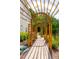 Landscaped backyard pathway shaded by a wooden arbor, leads to outdoor living spaces at 113 Hidden Bluff Dr, Chapel Hill, NC 27517
