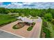Aerial view of a gated entrance featuring brick drive, lush landscaping, and well-maintained greenery at 113 Hidden Bluff Dr, Chapel Hill, NC 27517