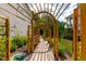Beautiful backyard garden path with a wooden pergola and string lights, offering a serene walkway at 113 Hidden Bluff Dr, Chapel Hill, NC 27517