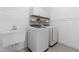 Bright laundry room with modern washer, dryer, shiplap walls, and white storage at 113 Hidden Bluff Dr, Chapel Hill, NC 27517