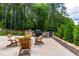 Outdoor stone kitchen and patio with mature trees in the background offer ultimate privacy at 113 Hidden Bluff Dr, Chapel Hill, NC 27517