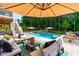 Beautiful outdoor pool with lounge seating and shaded patio area perfect for entertaining guests at 113 Hidden Bluff Dr, Chapel Hill, NC 27517