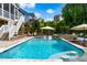 Beautiful backyard pool with built in bar stools, and surrounding greenery at 113 Hidden Bluff Dr, Chapel Hill, NC 27517