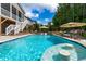 Luxurious backyard pool area featuring a swim-up bar, patio umbrellas, and a spacious deck at 113 Hidden Bluff Dr, Chapel Hill, NC 27517