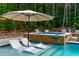 Modern pool and spa featuring built-in loungers and an umbrella, creating an ideal backyard retreat at 113 Hidden Bluff Dr, Chapel Hill, NC 27517