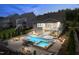 Aerial view of a backyard pool, spa, and patio area with outdoor seating, perfect for evening relaxation at 113 Hidden Bluff Dr, Chapel Hill, NC 27517