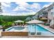 Backyard pool features a spa, tanning ledge, outdoor kitchen, and a beautiful green landscape at 113 Hidden Bluff Dr, Chapel Hill, NC 27517