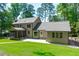 Spacious backyard featuring a patio, screened-in porch, lush green lawn, and mature trees at 11817 Coachmans Way, Raleigh, NC 27614