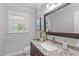 Bathroom features marble vanity, copper fixtures, toilet, and a decorative mirror and painting at 11817 Coachmans Way, Raleigh, NC 27614