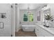 Luxurious bathroom with a standalone tub, elegant lighting, and double vanity at 11817 Coachmans Way, Raleigh, NC 27614