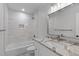 Elegant bathroom features a shower-tub combination and granite counters with white cabinets at 11817 Coachmans Way, Raleigh, NC 27614