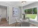 Breakfast nook features a white table, three chairs, and a large window with a view of the yard at 11817 Coachmans Way, Raleigh, NC 27614