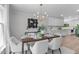 Dining room featuring modern chandelier, table set for six, and white cabinets in adjacent room at 11817 Coachmans Way, Raleigh, NC 27614