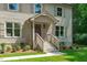 Close-up of front porch with brick stairs, white railings, and a stylishly painted front door and manicured landscaping at 11817 Coachmans Way, Raleigh, NC 27614