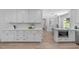 Bright kitchen with all-white cabinets, marble countertops, and stainless steel built-in microwave at 11817 Coachmans Way, Raleigh, NC 27614