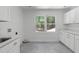 Bright laundry room featuring modern sink, cabinets, and large window for natural light at 11817 Coachmans Way, Raleigh, NC 27614