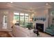 Cozy living room with a fireplace, and large windows offering a view of a nearby pond at 1205 Bridgeforth Ln, Chapel Hill, NC 27517