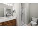 Bathroom featuring a shower, toilet and sink with a mirror above it, plus a view into the primary bedroom at 12505 Garden Tree Ln, Raleigh, NC 27614