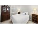 Cozy bedroom with white comforter, dark wood furnishings and plantation shutters at 12505 Garden Tree Ln, Raleigh, NC 27614