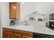 A kitchen featuring light countertops, wooden cabinets, an open layout to the living room and a fireplace at 12505 Garden Tree Ln, Raleigh, NC 27614