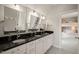 Bright bathroom with multiple sinks, black countertops, and views of bedroom at 129 Ruskin Dr, Chapel Hill, NC 27516