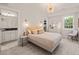 Cozy bedroom with chandelier, plush bed, ensuite bathroom, and ample natural light at 129 Ruskin Dr, Chapel Hill, NC 27516