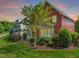 View of the exterior of a red two-story home with a screened in porch and manicured lawn at 129 Ruskin Dr, Chapel Hill, NC 27516