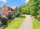 Beautiful home with a green lawn, mature trees, and a nearby walking path on a sunny day at 129 Ruskin Dr, Chapel Hill, NC 27516