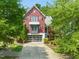 Charming two-story home with a red exterior, glass garage door and landscaped yard at 129 Ruskin Dr, Chapel Hill, NC 27516
