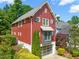 Charming two-story home with a red exterior, glass garage door and landscaped yard at 129 Ruskin Dr, Chapel Hill, NC 27516