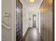 Long hallway with hardwood floors, a decorative mirror, and natural light from windows at 129 Ruskin Dr, Chapel Hill, NC 27516