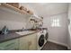 Functional laundry room with sink, washer/dryer, storage shelves, and natural light at 129 Ruskin Dr, Chapel Hill, NC 27516