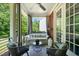 Inviting covered porch with stylish seating, curtains, ceiling fan, and peaceful outdoor views at 129 Ruskin Dr, Chapel Hill, NC 27516