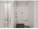 Modern bathroom shower with black and white tile, glass enclosure, and marble bench at 129 Ruskin Dr, Chapel Hill, NC 27516