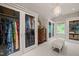 Bright walk-in closet with glass doors, custom shelving, stylish chandelier, and cushioned bench at 129 Ruskin Dr, Chapel Hill, NC 27516