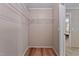 Walk-in closet featuring neutral-toned paneling, laminate flooring, and wire shelving system at 130 S Creek Dr, Louisburg, NC 27549