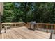Wood deck with a stainless steel gas grill and a wooden railing around the perimeter at 130 S Creek Dr, Louisburg, NC 27549