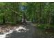 Long gravel driveway leading through a lush, green, wooded area to the home at 130 S Creek Dr, Louisburg, NC 27549
